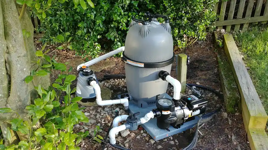 Jandy cartridge filter and variable pump plumbed in white PVC on a gravel pad