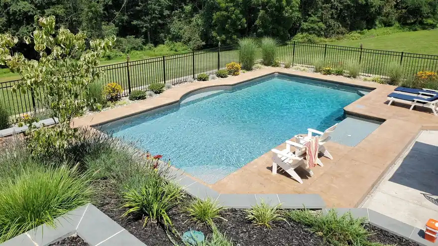 Rectangular pool with a sun shelf, flagstone coping and ornamental grasses